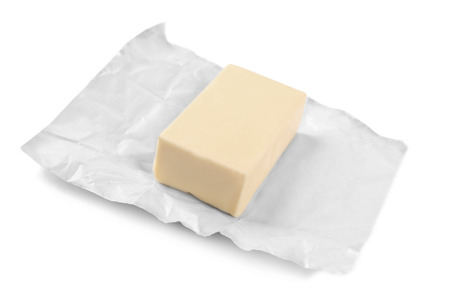 Wrapping with piece of butter on white backgroundの写真素材