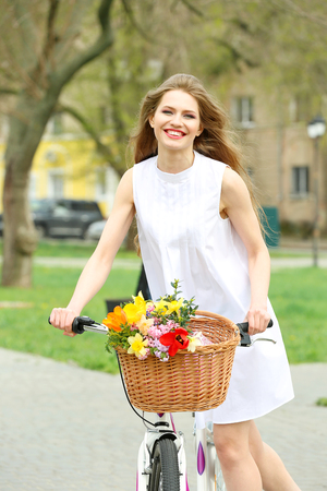 Young smiling girl cycling in parkの写真素材