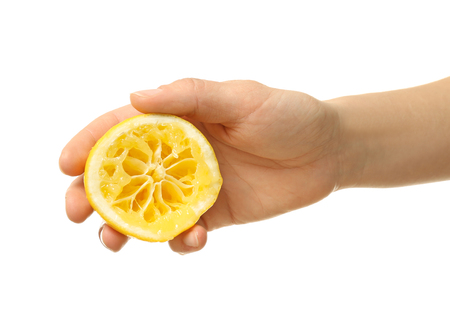 Female hand holding half of lemon on white backgroundの写真素材