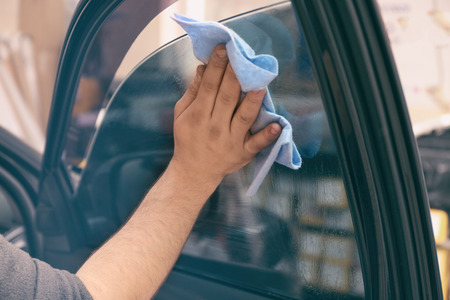 Worker polishing tinted car windowの写真素材