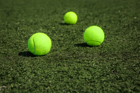 Tennis balls on fresh green grass outdoorsの写真素材