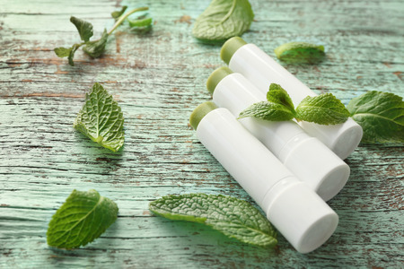 Hygienic lipsticks with lemon balm on wooden backgroundの写真素材