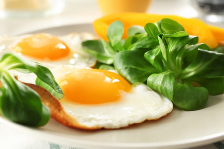 Tasty breakfast with fried eggs on plate, closeup