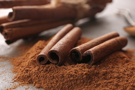 Closeup view of cinnamon sticks and powder on tableの写真素材