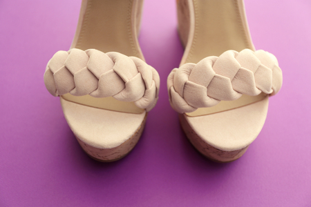Pair of beautiful shoes on purple background