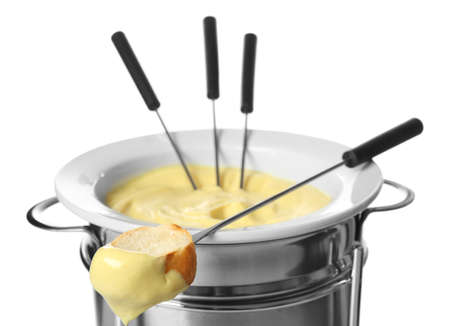 Cheese fondue in pot and piece of bread on stick against white backgroundの写真素材