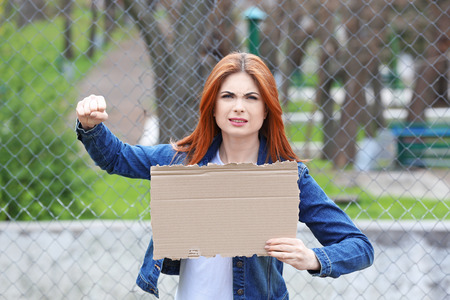 Protesting young woman holding piece of cardboard with space for text on streetの写真素材