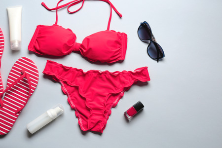 Red bikini and beach accessories on light backgroundの写真素材