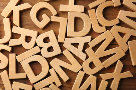 Different letters on wooden background