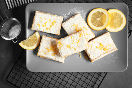 Plate with delicious lemon pie bars on cooling rackの写真素材