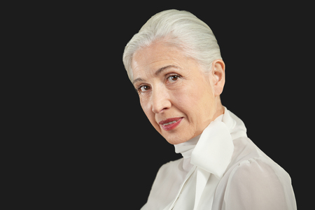 Beautiful elderly woman on black backgroundの写真素材