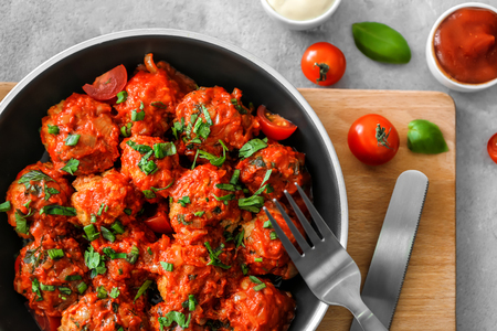 Frying pan with turkey meatballs and tomato sauce on tableの写真素材