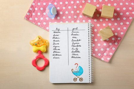 Composition with list of baby names in notebook on wooden backgroundの写真素材