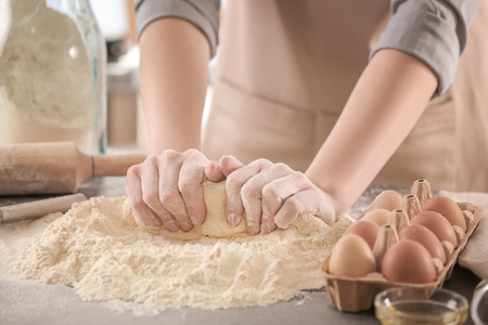 Female chef making dough in kitchenの写真素材