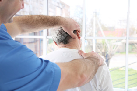 Physiotherapist working with elderly patient in clinicの写真素材
