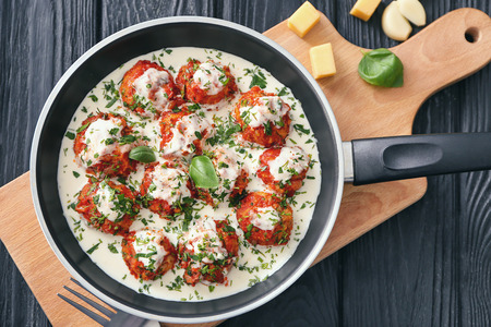 Frying pan with delicious turkey meatballs and sauce on tableの写真素材