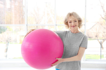 Senior woman with fitball in rehabilitation clinic. Physiotherapy conceptの写真素材