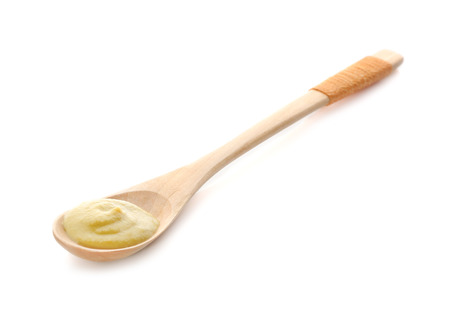 Spoon with delicious mustard sauce on white backgroundの写真素材