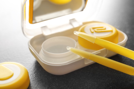 Tweezers and plastic container for contact lenses on gray background, closeupの写真素材