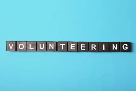 Volunteering concept. Wooden cubes on color backgroundの写真素材