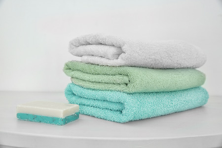 Stack of clean towels and soap on tableの写真素材