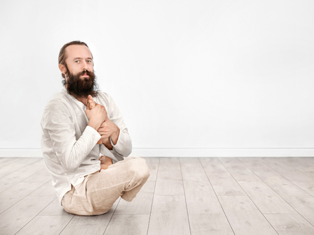 Young man practicing yoga on light wall backgroundの写真素材