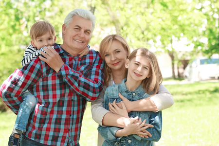 Cute happy children with grandparents in spring parkの写真素材