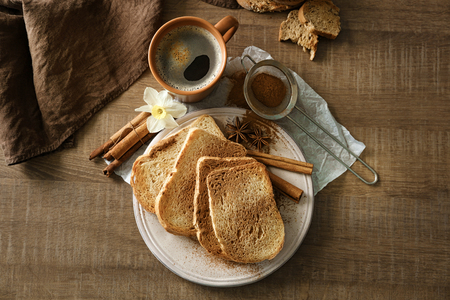 Plate with tasty cinnamon toasts on wooden tableの写真素材
