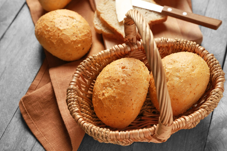 Wicker basket and delicious bread on wooden tableの写真素材
