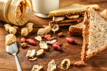 Tasty sandwiches with peanut butter and nuts on tableの写真素材