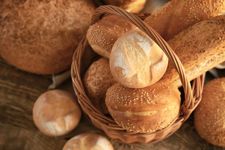Beautiful composition with wicker basket and delicious bread on wooden table