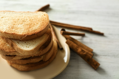 Plate with tasty cinnamon toasts on wooden tableの写真素材