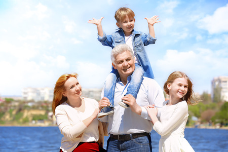 Cute happy children with grandparents walking on embankmentの写真素材