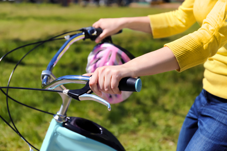 Young woman riding bike in park on sunny dayの写真素材