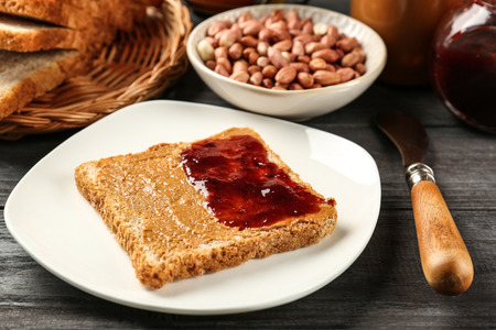 Tasty sandwich with peanut butter and jam on tableの写真素材