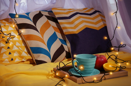 Stylish pillows on window sill with garland