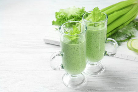 Glasses of fresh vegetable juice on wooden backgroundの写真素材
