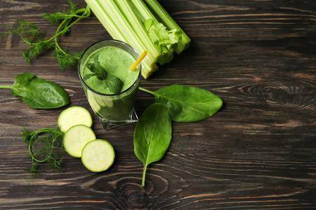 Glass of fresh vegetable juice on dark wooden backgroundの写真素材
