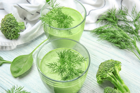 Glasses of fresh vegetable juice on wooden backgroundの写真素材
