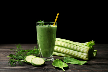 Glass of fresh vegetable juice on dark wooden tableの写真素材