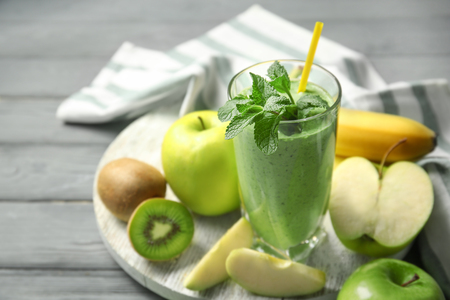 Glass of fresh juice and fruits on wooden backgroundの写真素材