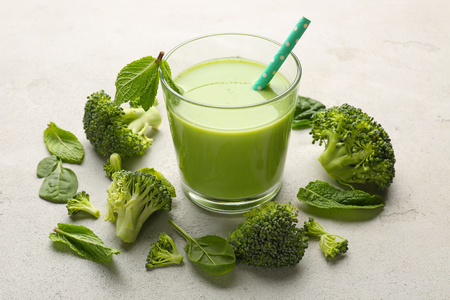 Glass with fresh green juice and ingredients on tableの写真素材