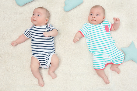 Beautiful baby twins lying together on plaid