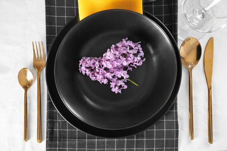 Beautiful table setting with lilac and golden cutleryの写真素材