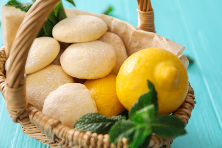 Wicker basket with homemade lemon cookies and fresh fruit, closeupの写真素材