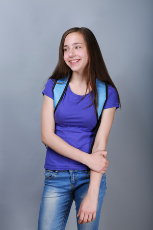 Cute pretty girl with schoolbag on color backgroundの写真素材