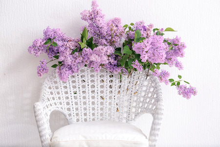 Beautiful lilac flowers on wicker armchairの写真素材
