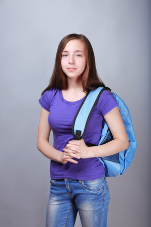 Cute pretty girl with schoolbag on color backgroundの写真素材