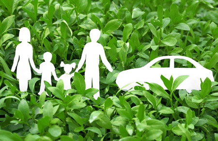 Paper silhouette of family with car in green grass. Insurance conceptの写真素材