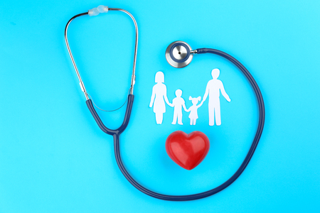 Paper silhouette of family, stethoscope and heart on color background. Health insurance conceptの写真素材